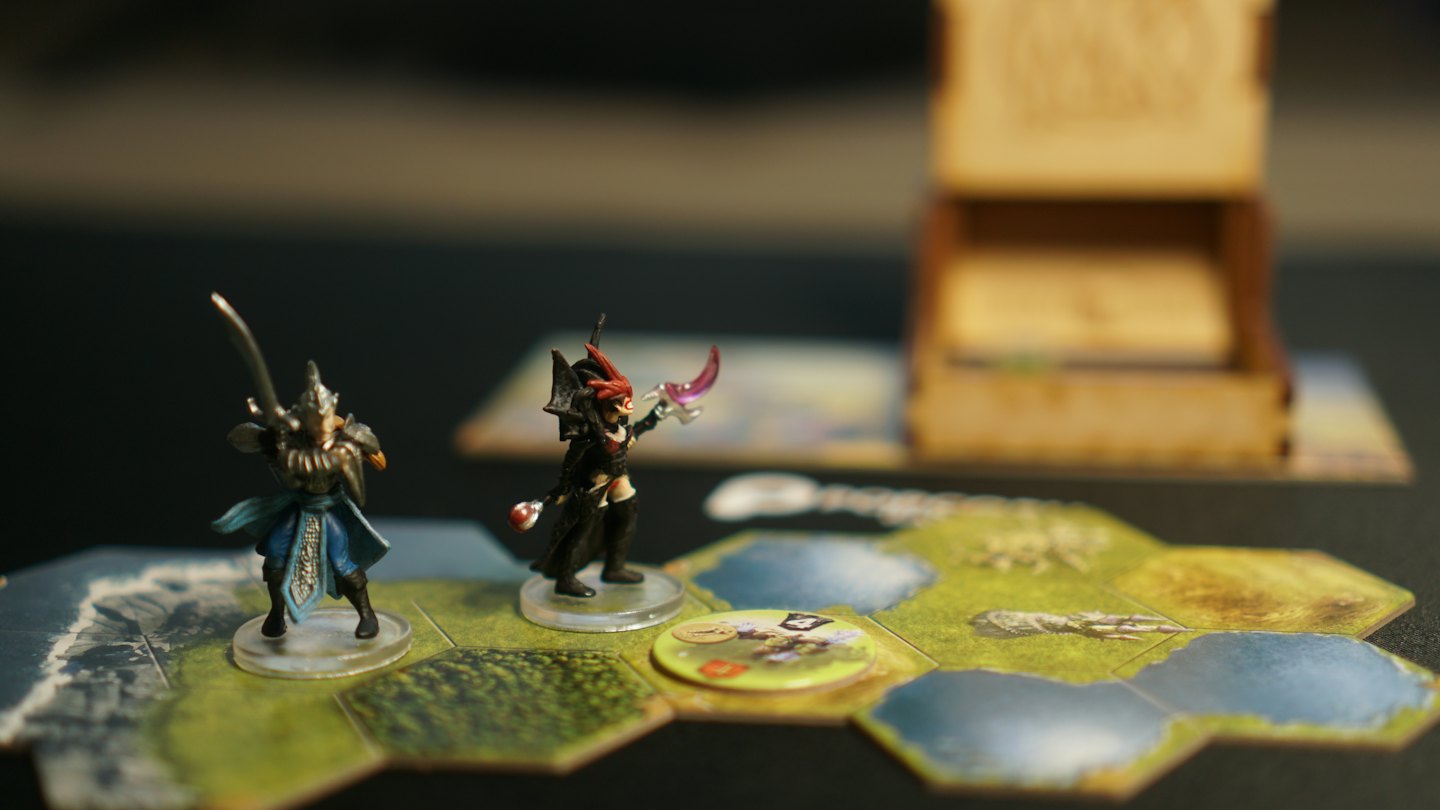 Figurki wojownika i maga fantasy stoją na planszy do gry.