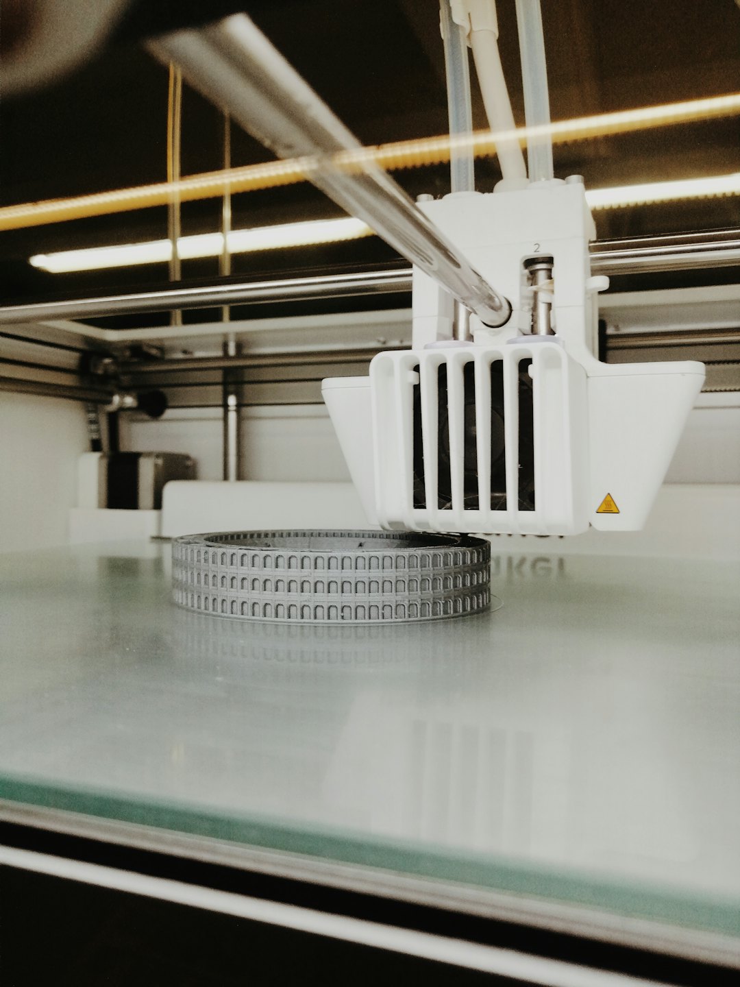 Drukarka 3D tworząca szczegółowy model architektoniczny na swoim polu roboczym.